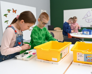 dzieci na lekcji budują modele z lego education w sali szkolnej. Są skupione na zadaniu.