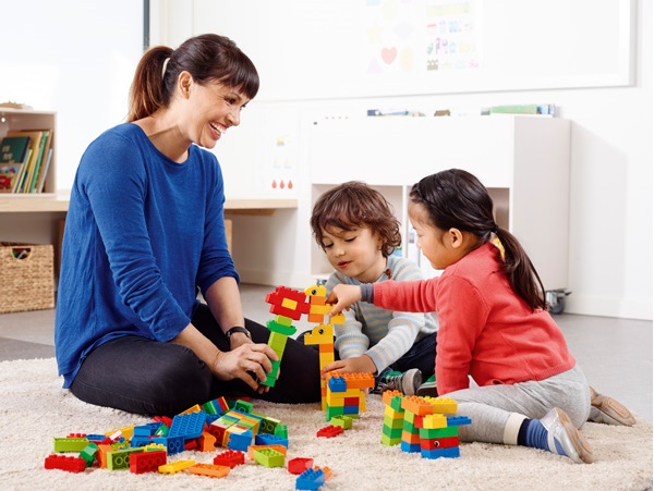 nauczyciel buduje wraz z dziećmi modele z klocków lego